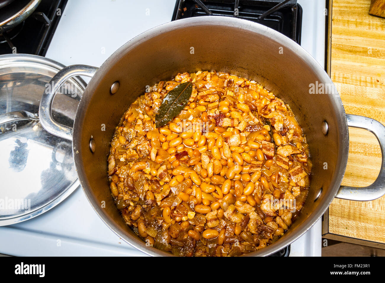 Canario beans cooked on a stove top in a stainless steal pot.  Also known as Peruano or mayacoba beans. Stock Photo