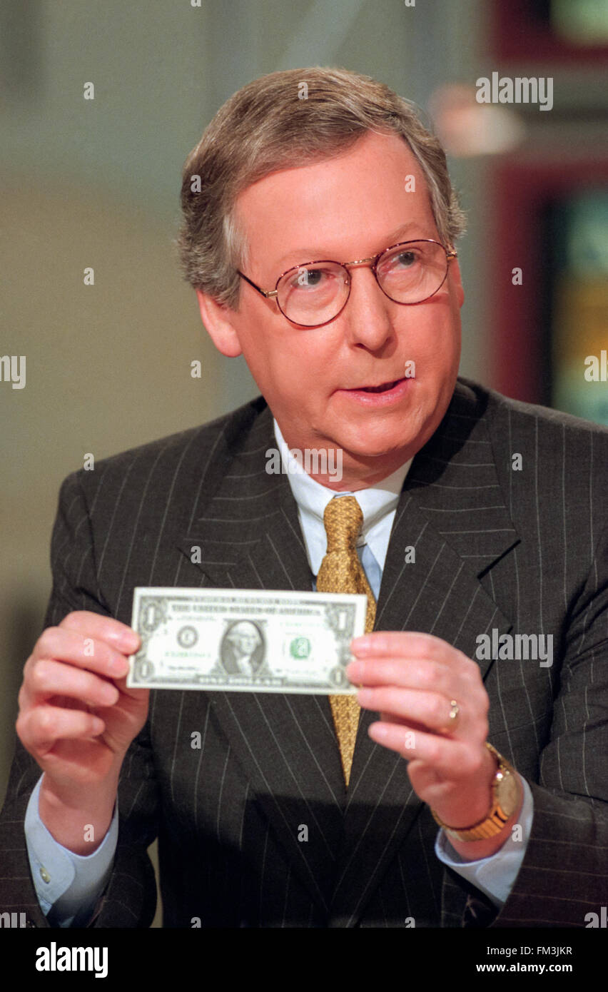 U.S Senator Mitch McConnell holds a dollar bill during discussions on the Republican tax cuts on NBC's Meet the Press August 1, 1999 in Washington, DC. Stock Photo