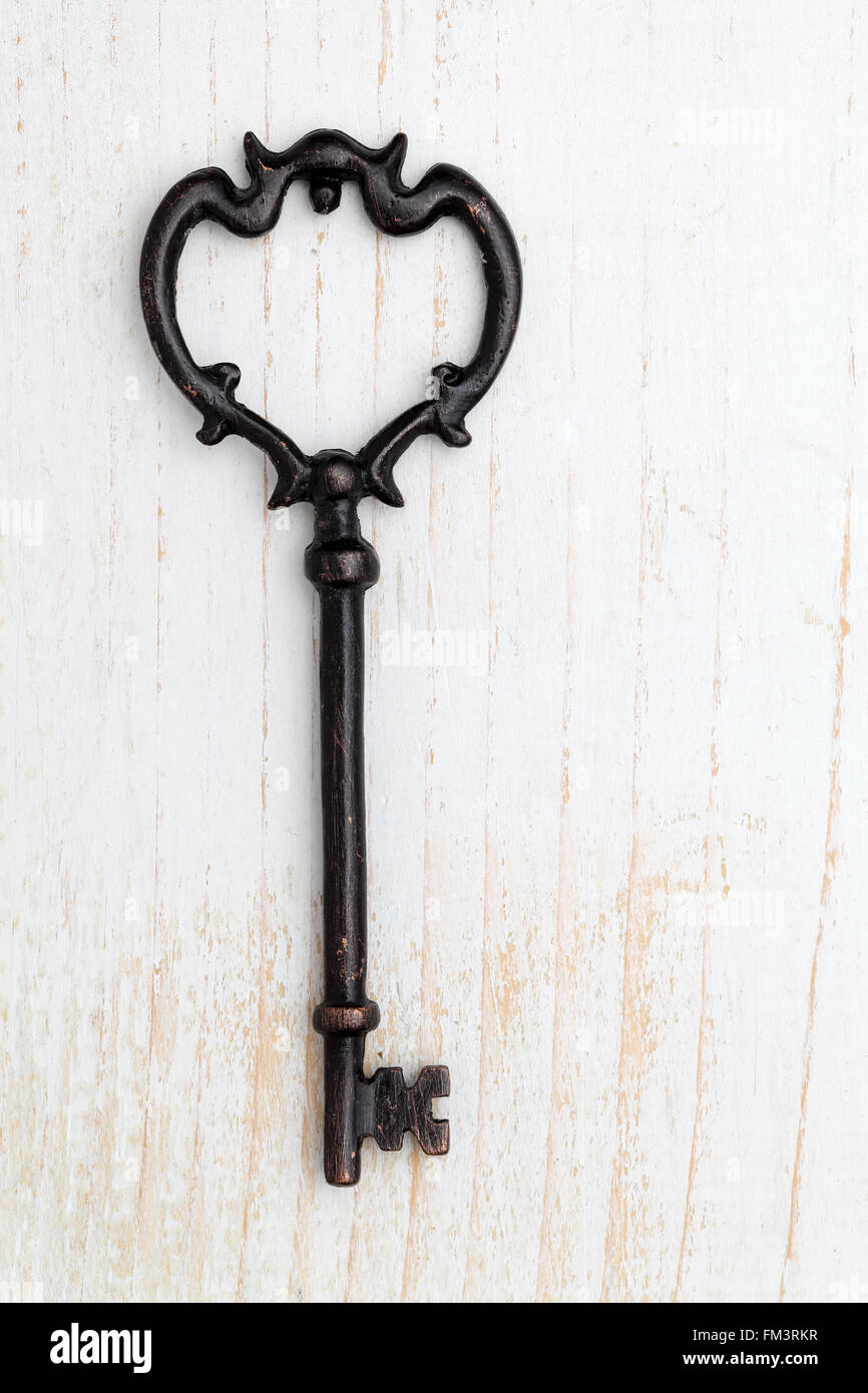 Antique key on white wood background Stock Photo - Alamy