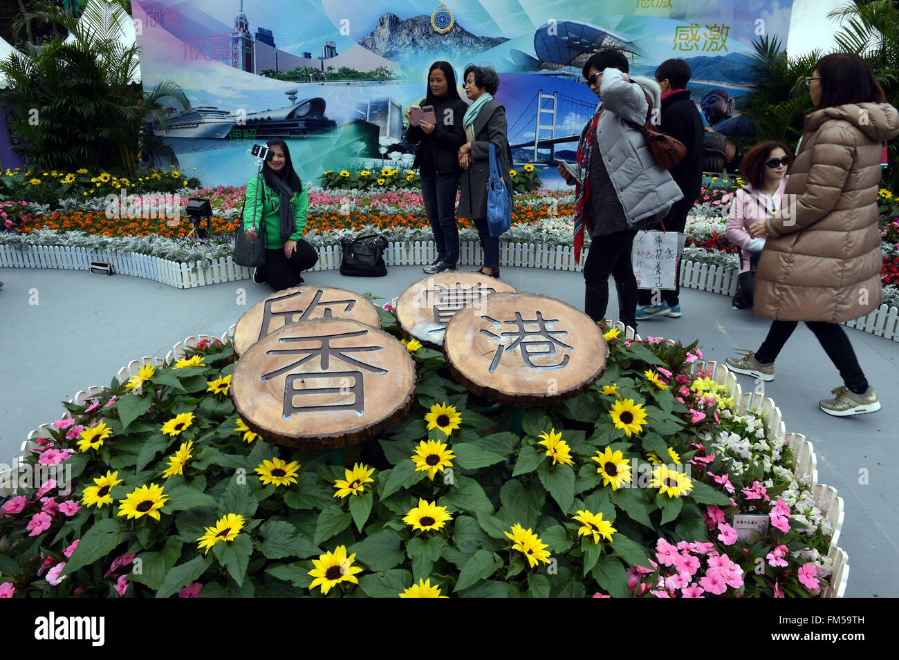 Hong Kong, China. 11th Mar, 2016. Visitors take photos of flowers