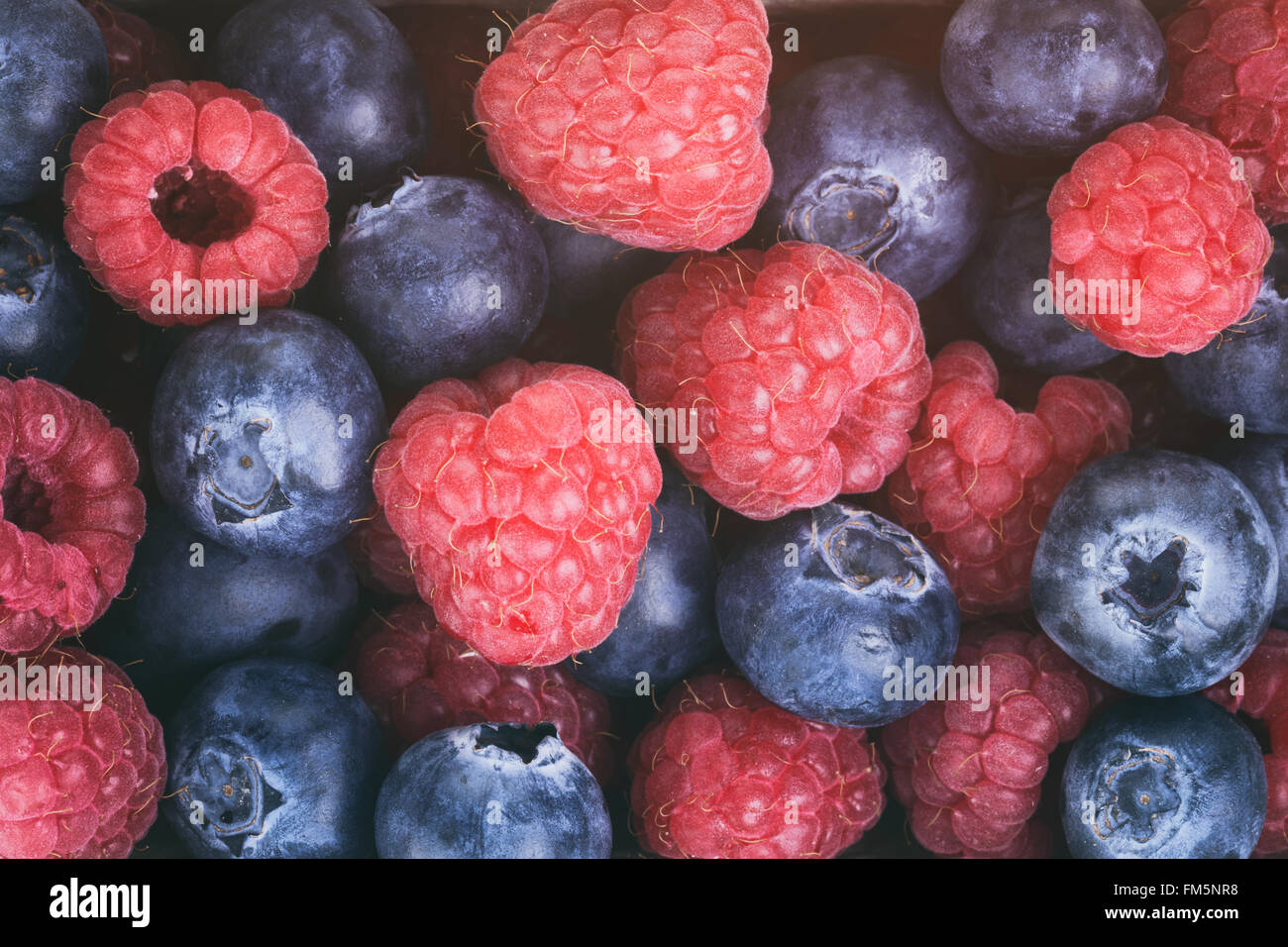 Blueberry Raspberry Size Comparison fresh raspberries and blueberries top view background Stock Photo - Alamy