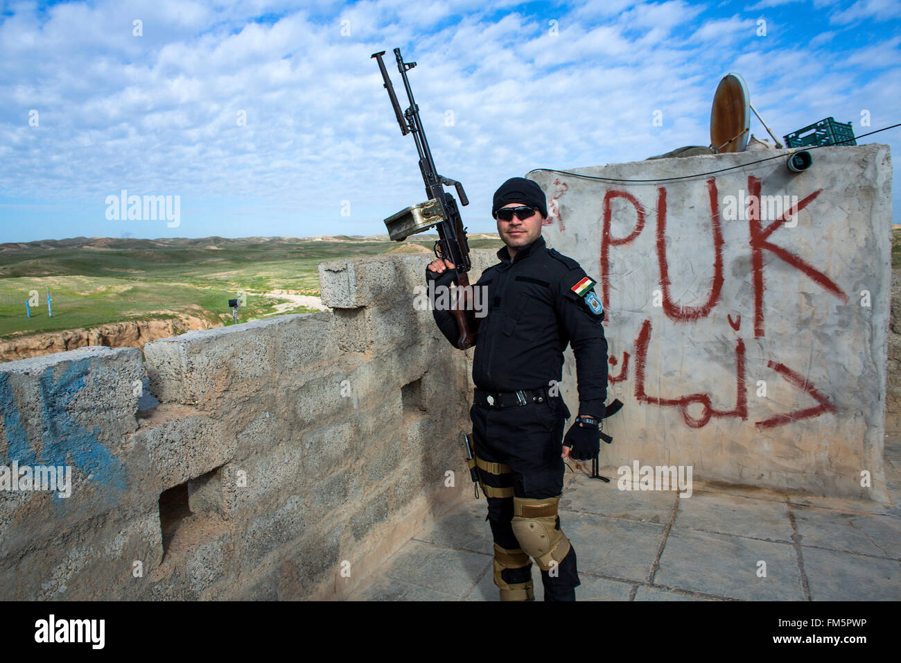 Kurdish fighter at a road checkpoint near the frontline with IS in Northern Iraq Stock Photo