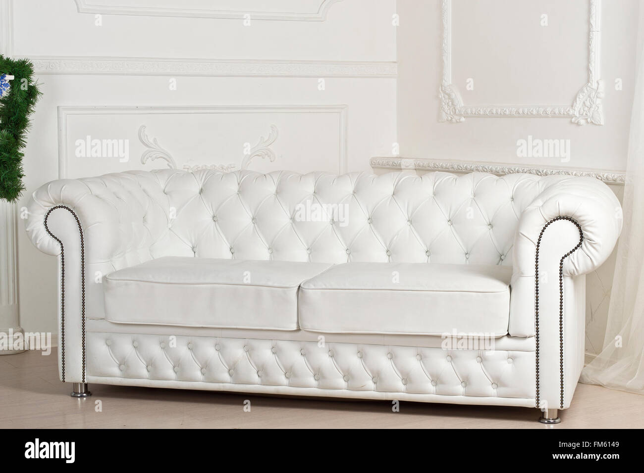 White leather sofa in Christmas decorations. Studio interiors in Christmas style and bright colours Stock Photo