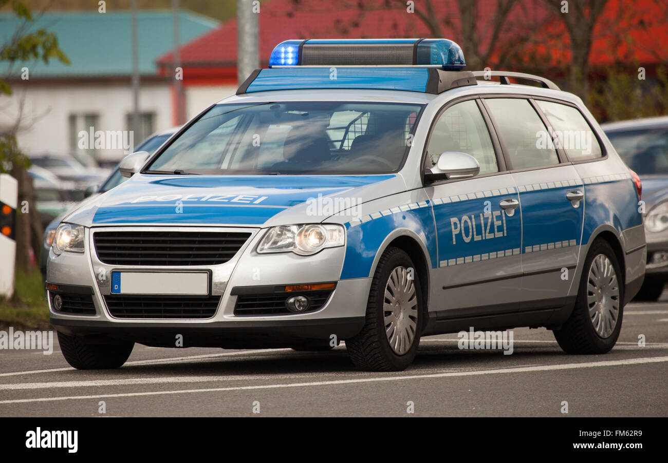 german police patrol car with flashing blue lights on the street Stock Photo