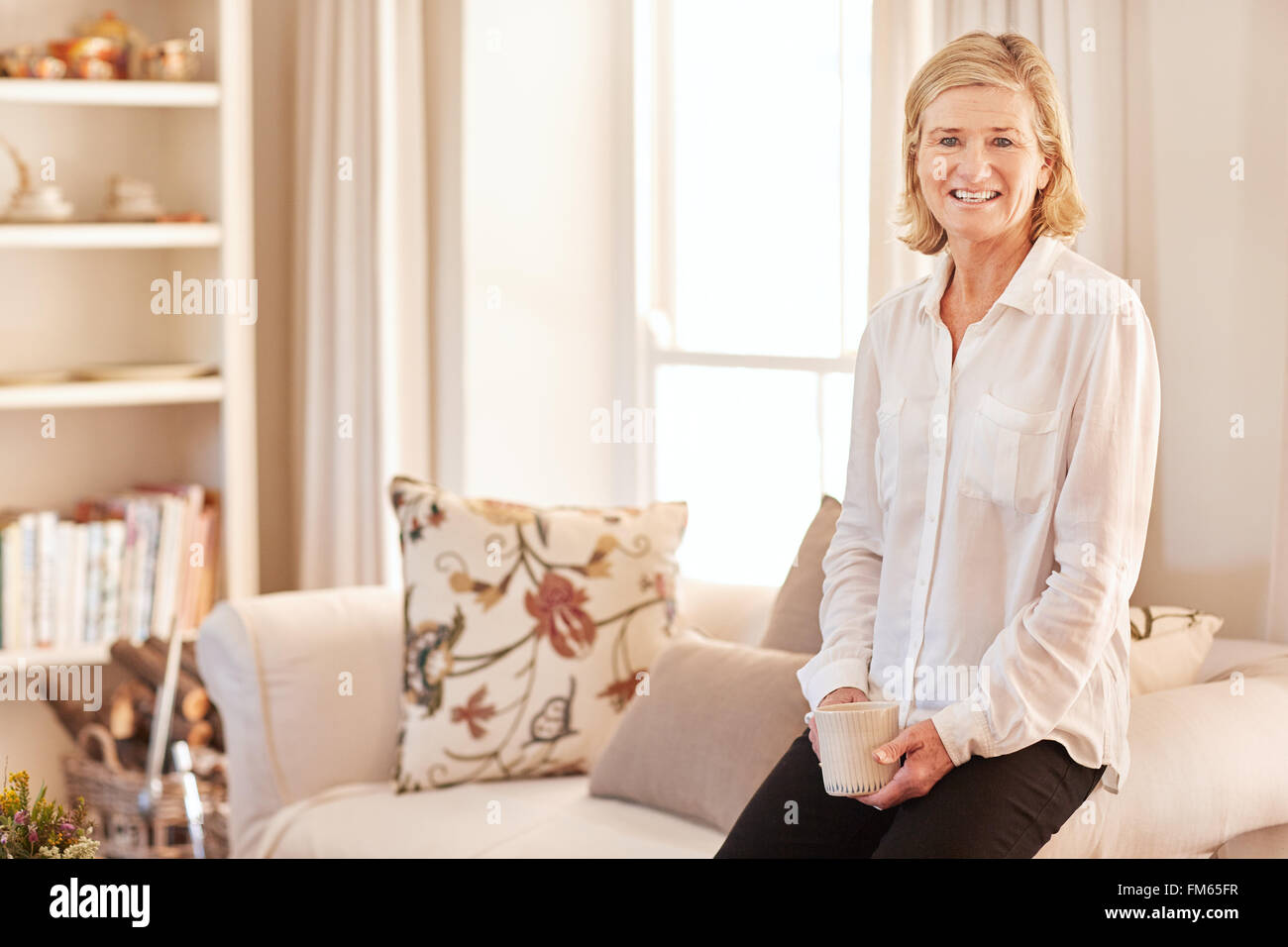 Confident senior woman in her bright and tidy living room Stock Photo