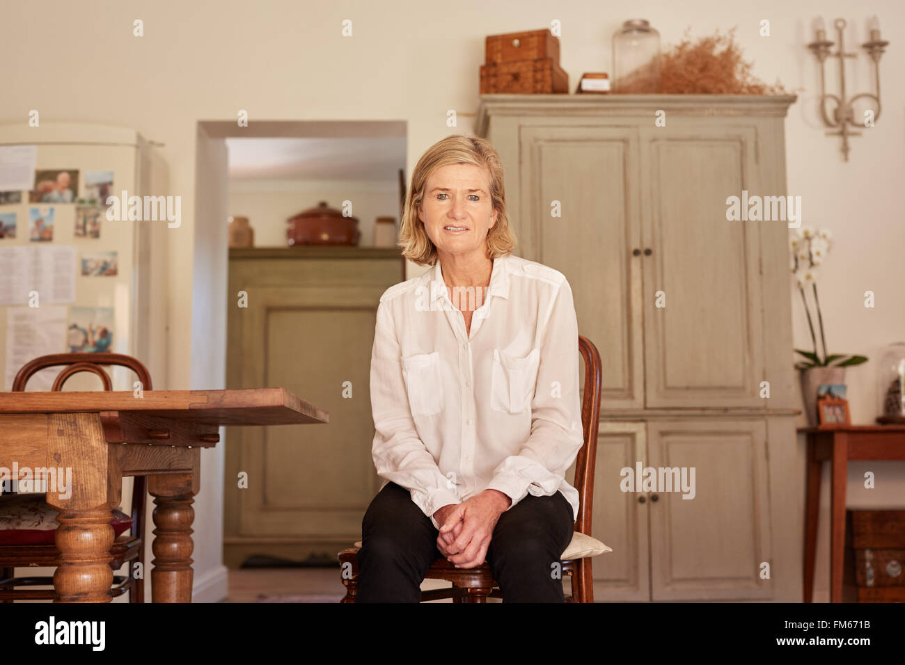 Modern senior woman sitting in her rustic style home Stock Photo