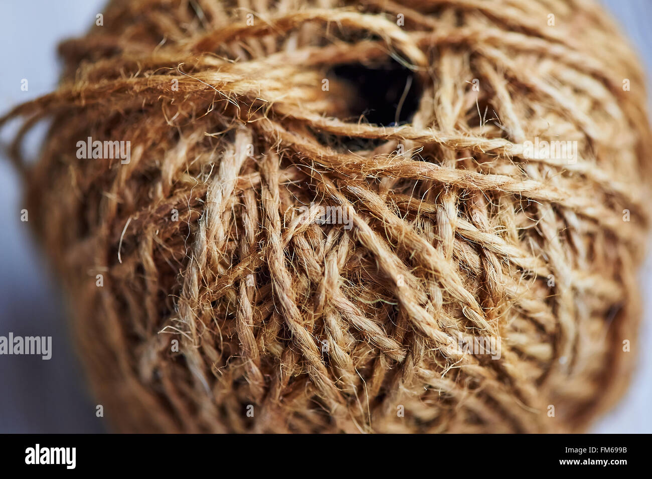 A roll of natural brown rope on a wooden countertop Stock Photo - Alamy