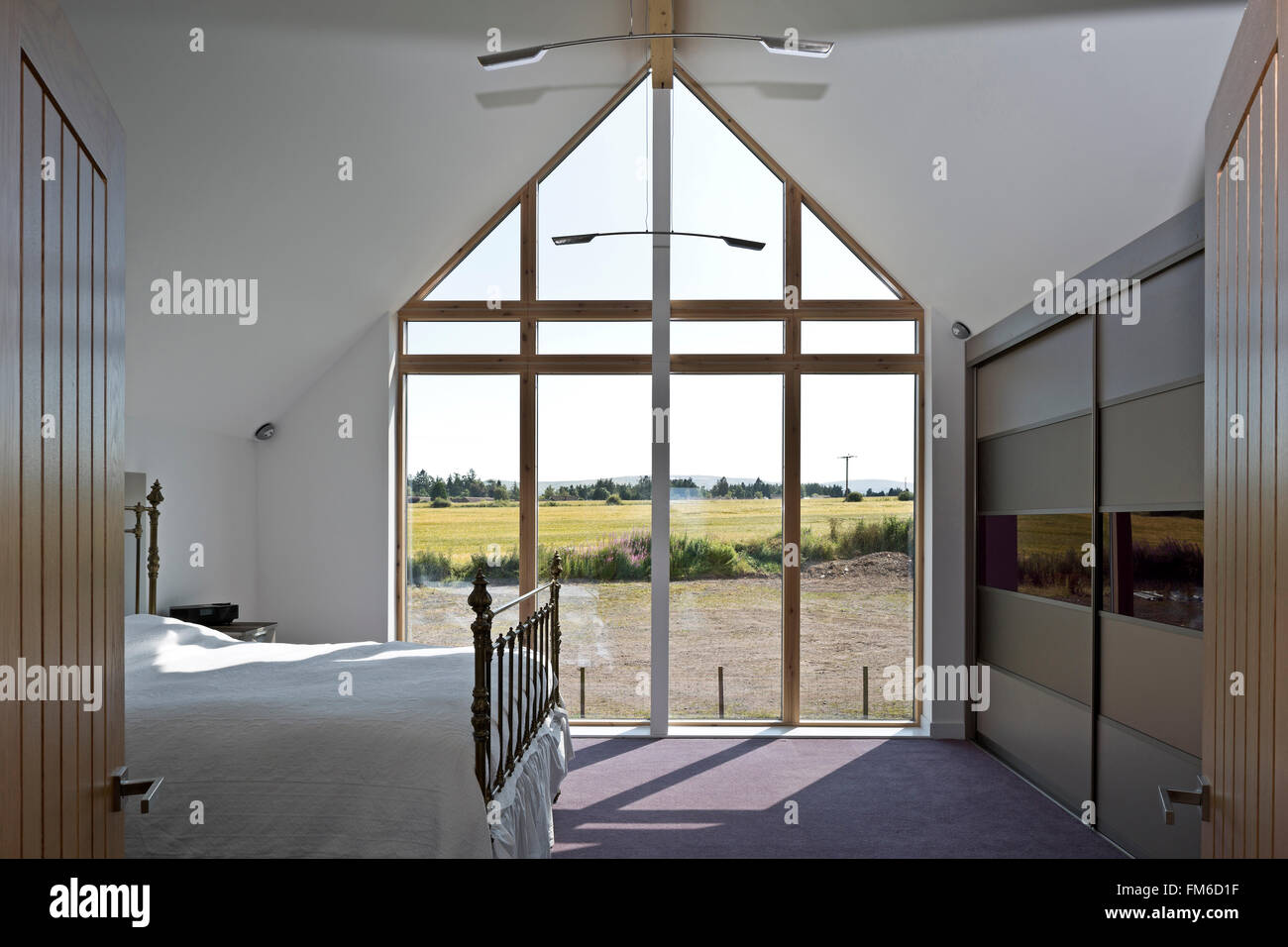 An interior view of a modern residential property called the Amor House, in Gleneagles, showing the large window to the bedroom. Stock Photo