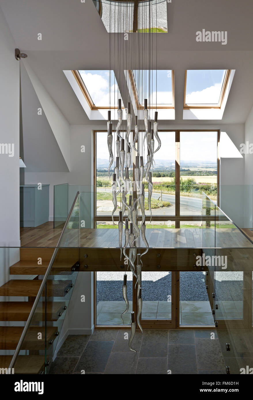 An interior view of a modern residential property called the Amor House, in Gleneagles, showing a part of the staircase and the large windows. Stock Photo