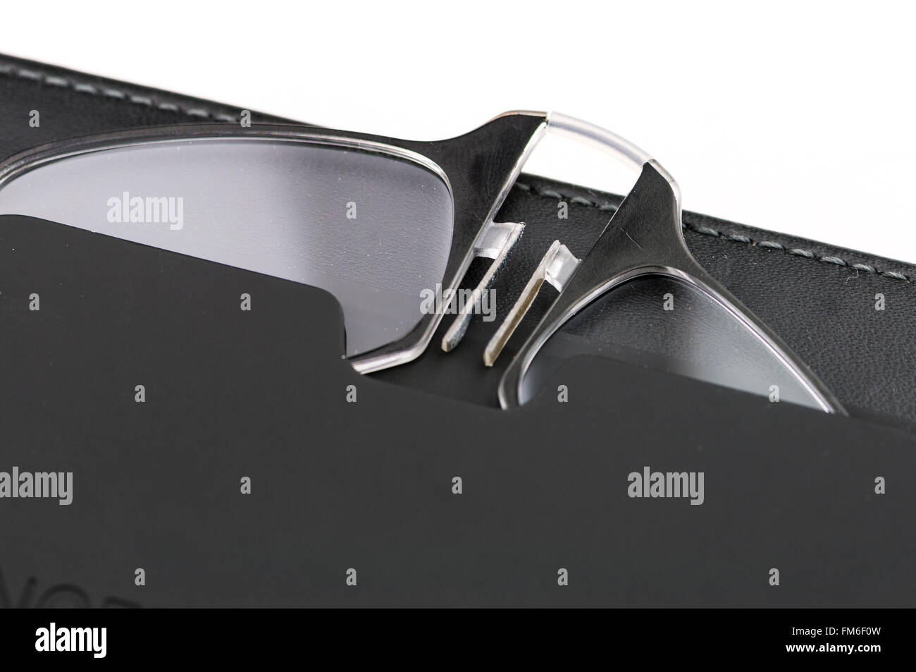 ThinOptics reading glasses in a case stuck to a mobile phone case Stock