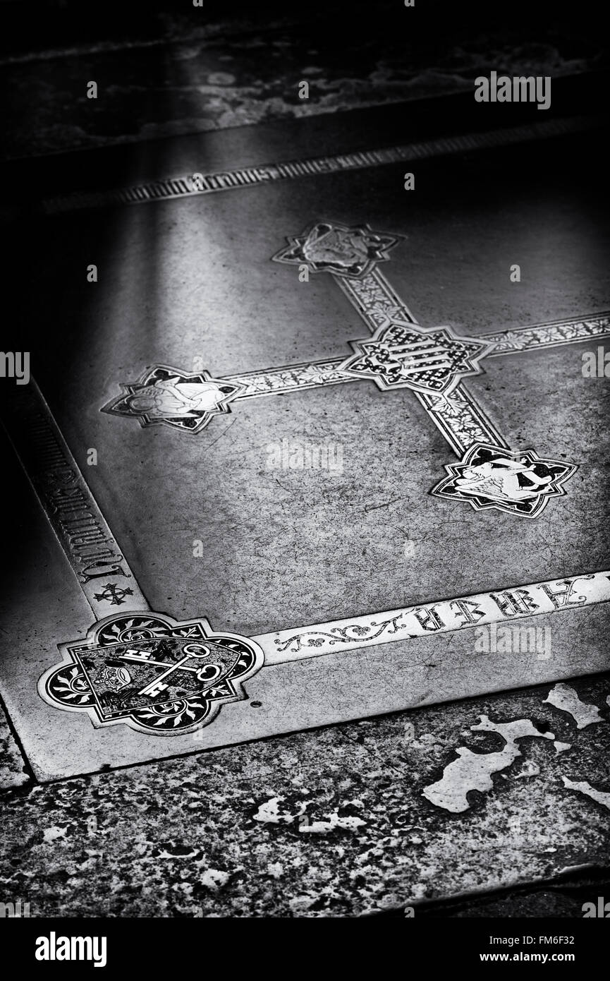 Black purbeck ledger with crossed keys and victorian brass inlaid cross on the floor of the retrochoir in Wells Cathedral. UK Stock Photo