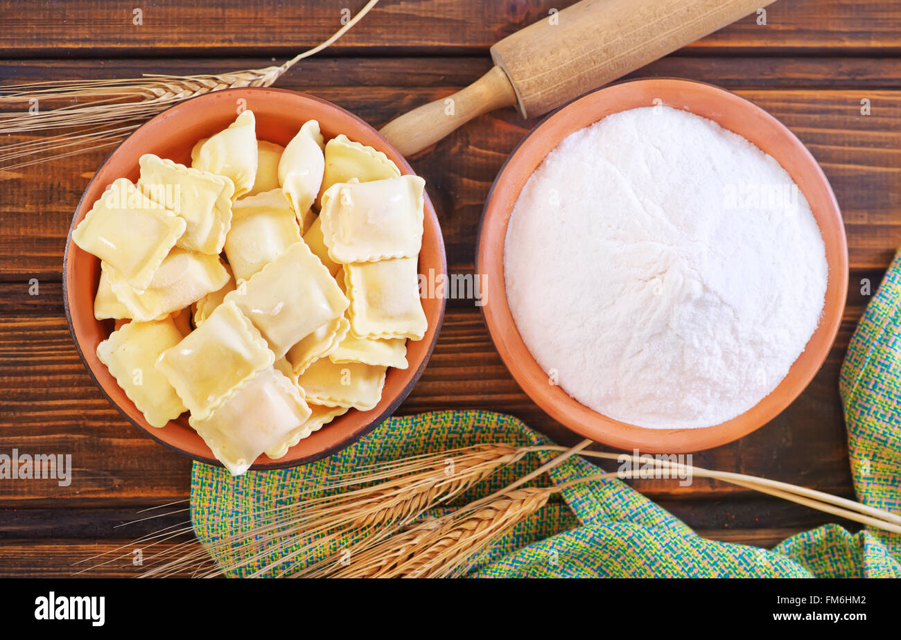 raw ravioli and flour on a table Stock Photo - Alamy