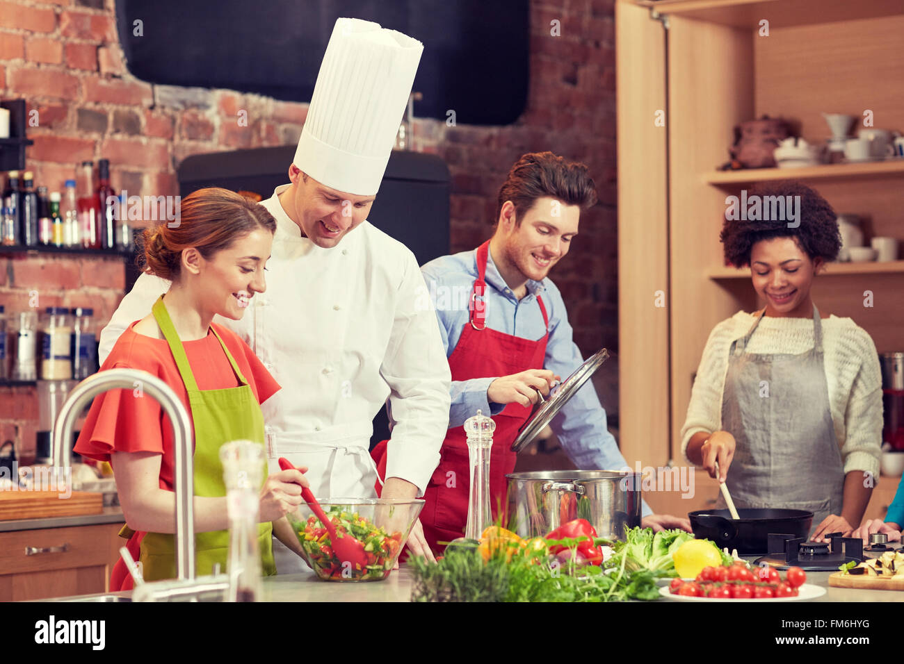 happy friends and chef cook cooking in kitchen Stock Photo - Alamy
