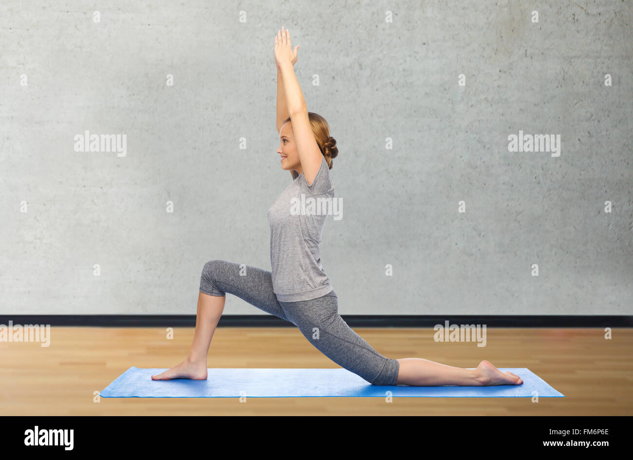 happy woman making yoga in low lunge on mat Stock Photo - Alamy