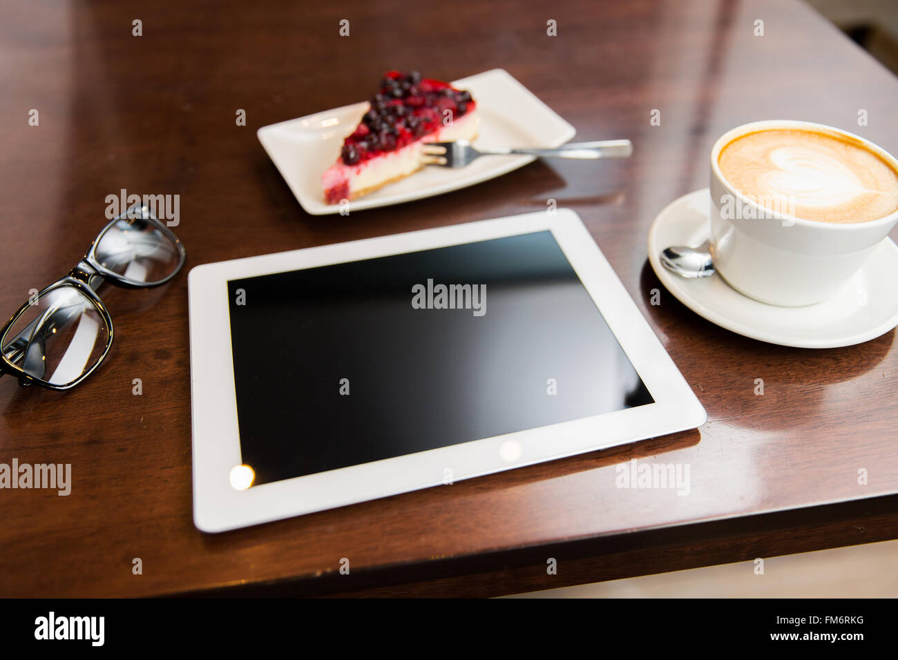 close up of tablet pc, coffee cup and cake Stock Photo