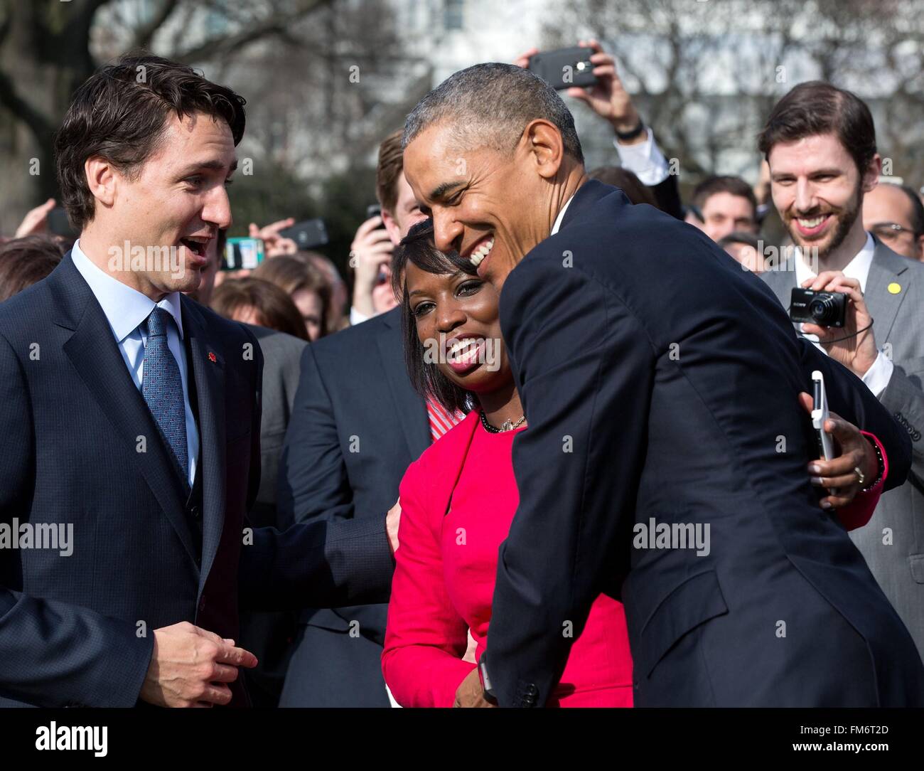 U.S. President Barack Obama hugs a member of the Canadian delegation as Canadian Prime Minister Justin Trudeau looks on during the State Arrival ceremony on the South Lawn of the White House March 10, 2016 in Washington, DC. This is the first state visit by a Canadian Prime Minister in 20-years. Stock Photo