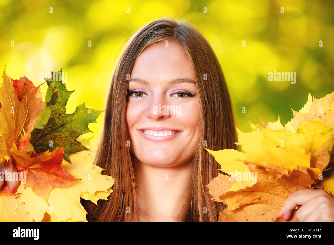 Fall season. Portrait of happy girl young woman holding colorful leaves ...