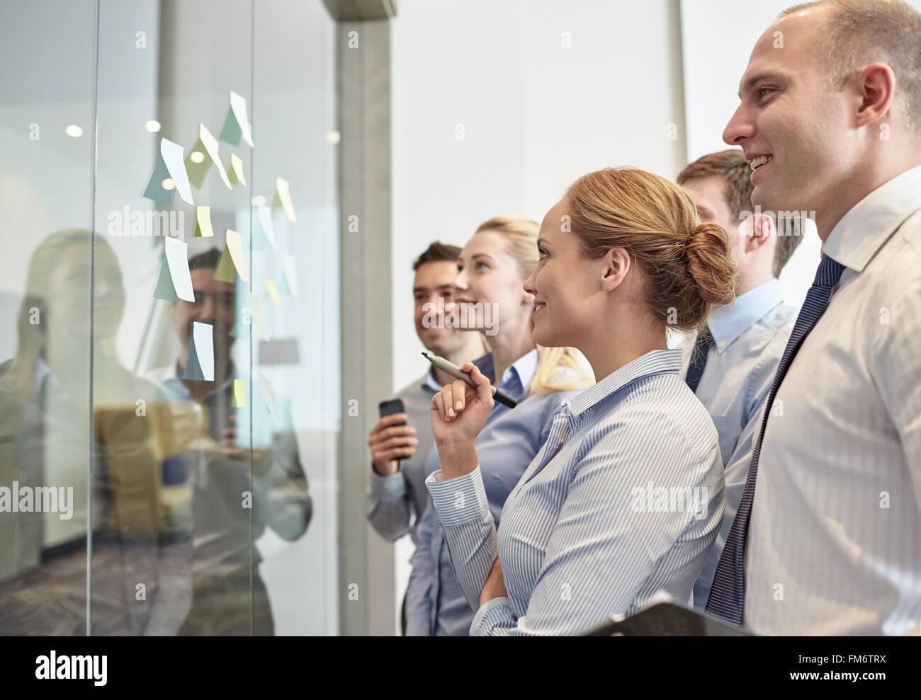 smiling business people with marker and stickers Stock Photo - Alamy