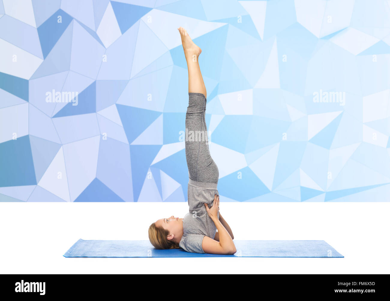 woman making yoga in shoulderstand pose on mat Stock Photo - Alamy