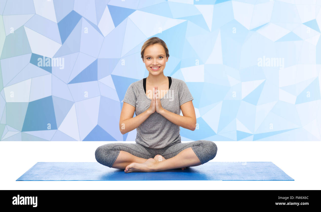 woman making yoga meditation in lotus pose on mat Stock Photo - Alamy