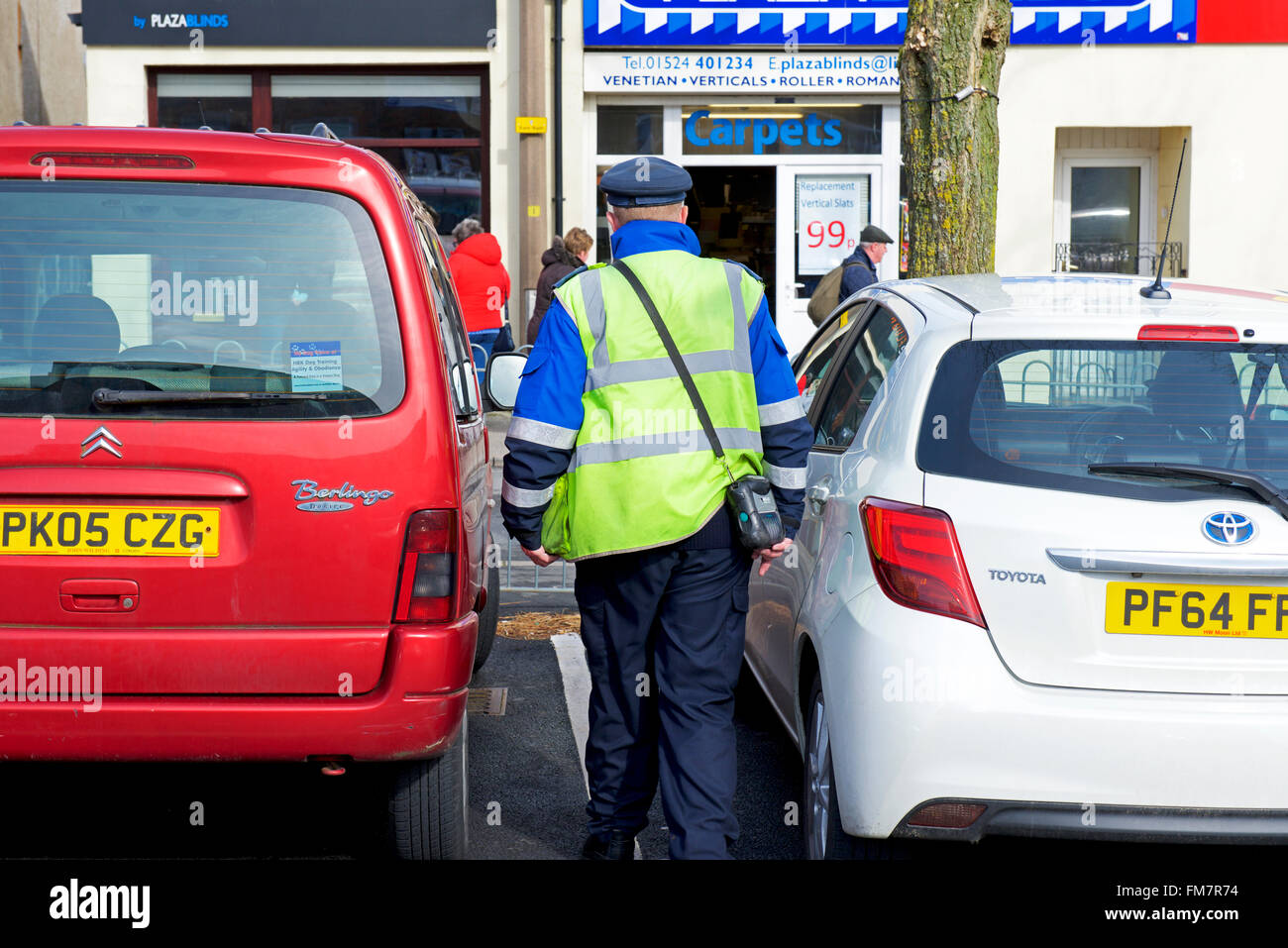 Traffic warden in car park, England UK Stock Photo