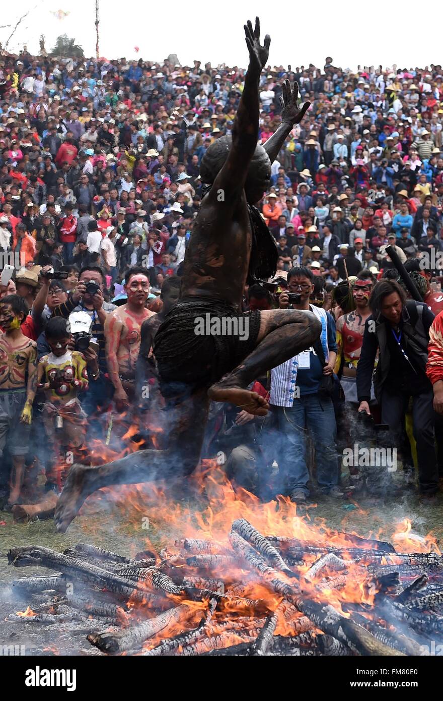 Mile, China's Yunnan Province. 11th Mar, 2016. A man of Yi ethnic group jumps over a bonfire to drive out ill fortune during the annual fire worshipping festival, which falls on the third day of the second month in the Chinese lunar calendar at Xiyi Township under Mile City, southwest China's Yunnan Province, March 11, 2016. Credit:  Lin Yiguang/Xinhua/Alamy Live News Stock Photo