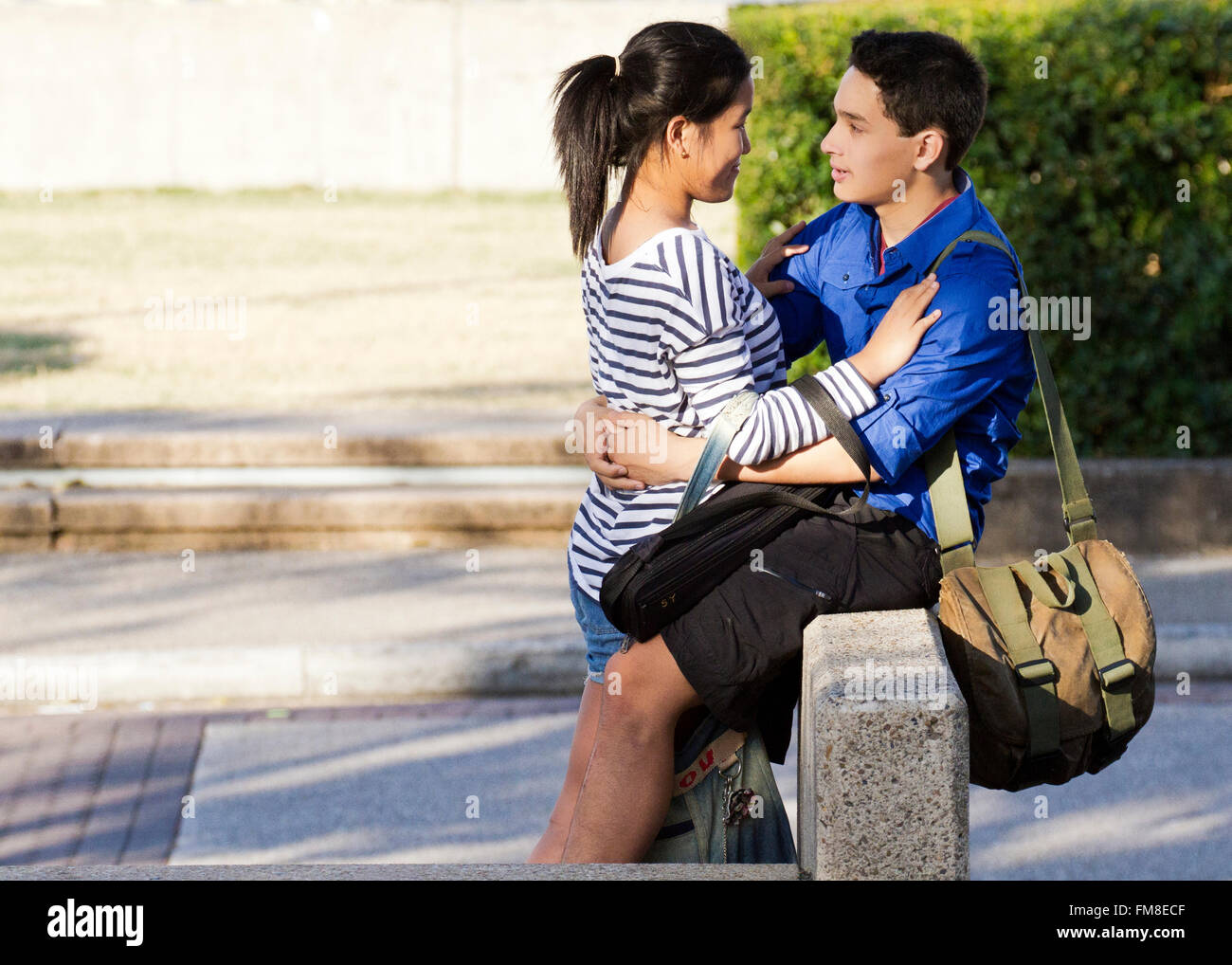multi racial student couple showing affection at south bank brisbane australia Stock Photo