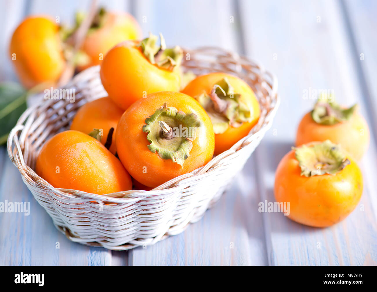 persimmon in basket and on a table Stock Photo Alamy
