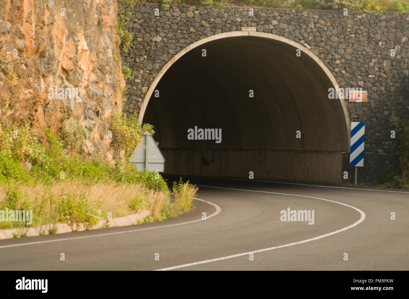 road tunnel tunnels tunneling through a  mountain mountains entrance arch arches solid rock tunneled dig dug digging excavating Stock Photo