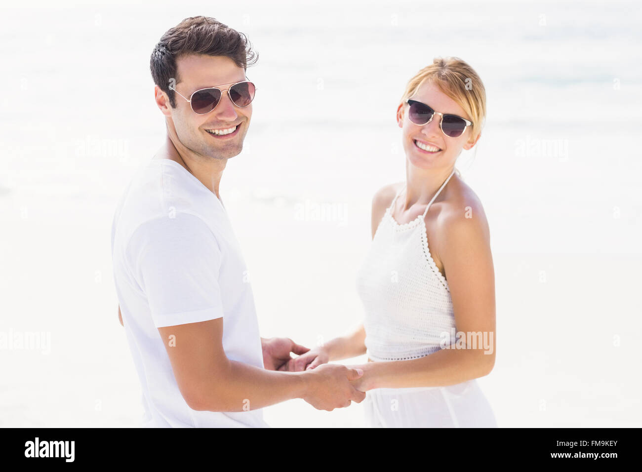 Romantic couple holding hands on the beach Stock Photo - Alamy