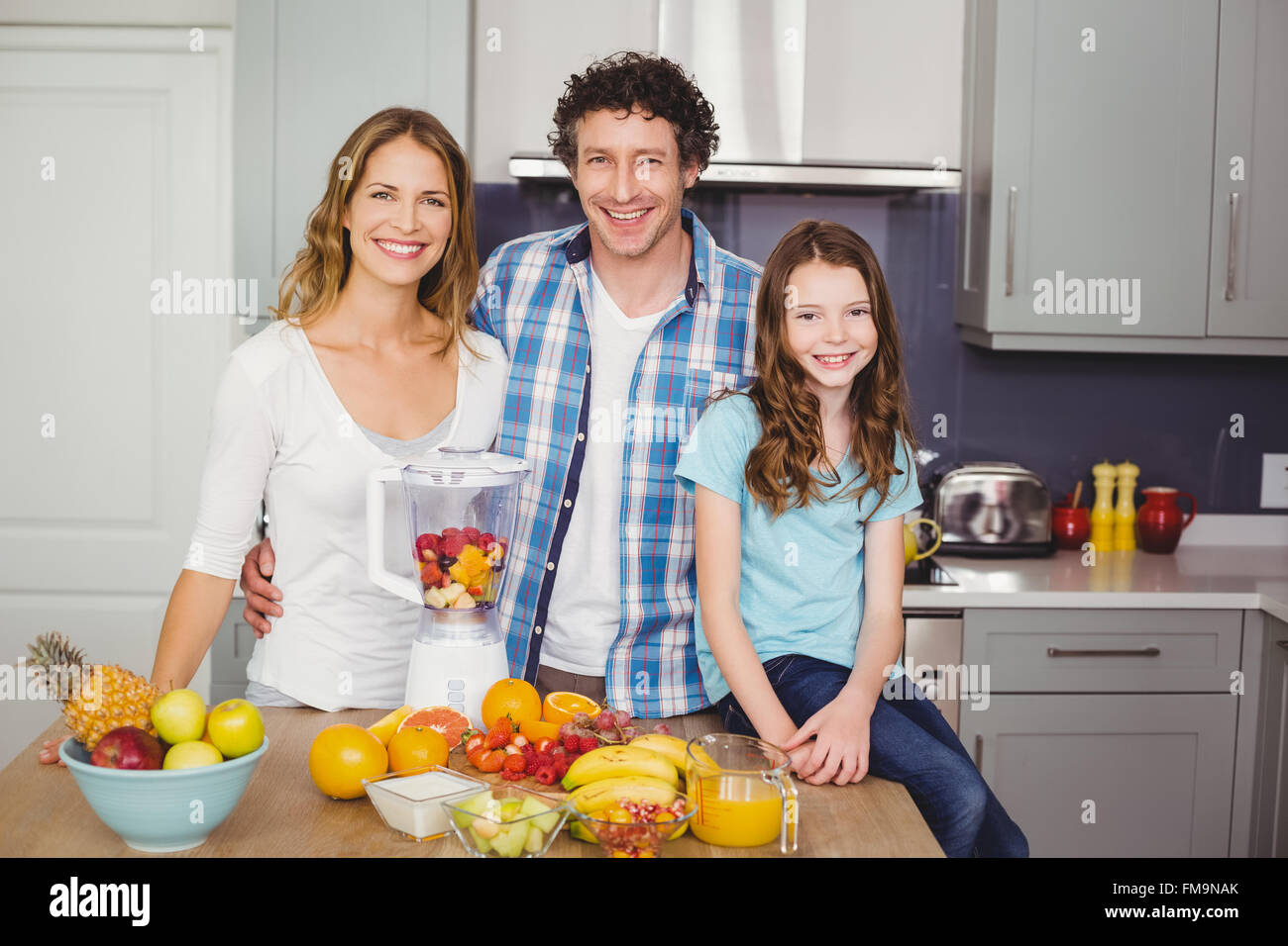 Portrait of smiling family standing at table Stock Photo - Alamy