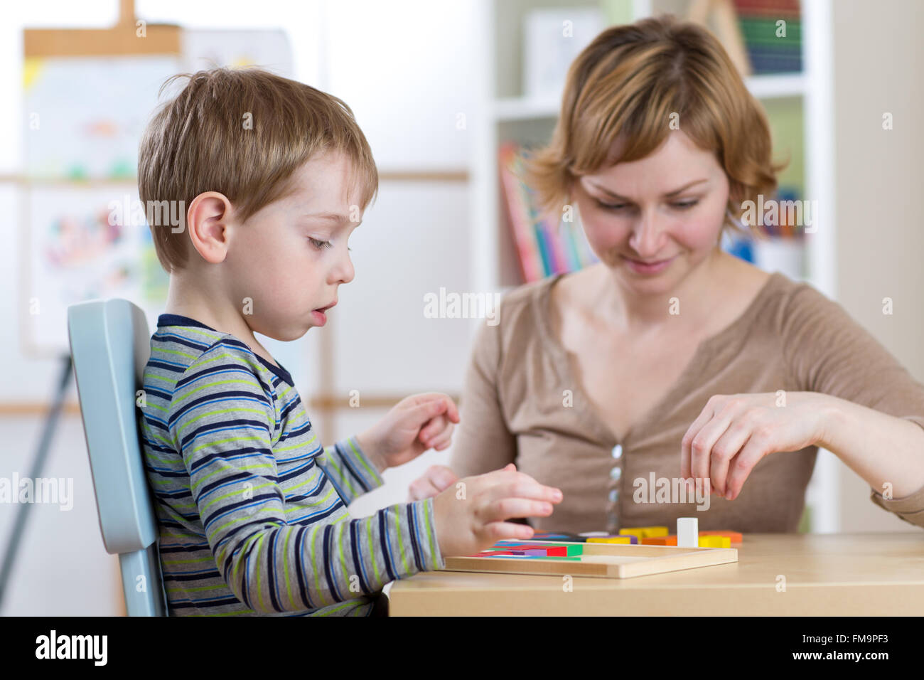 Child boy playing with education toys at the table in kindergarten Stock Photo
