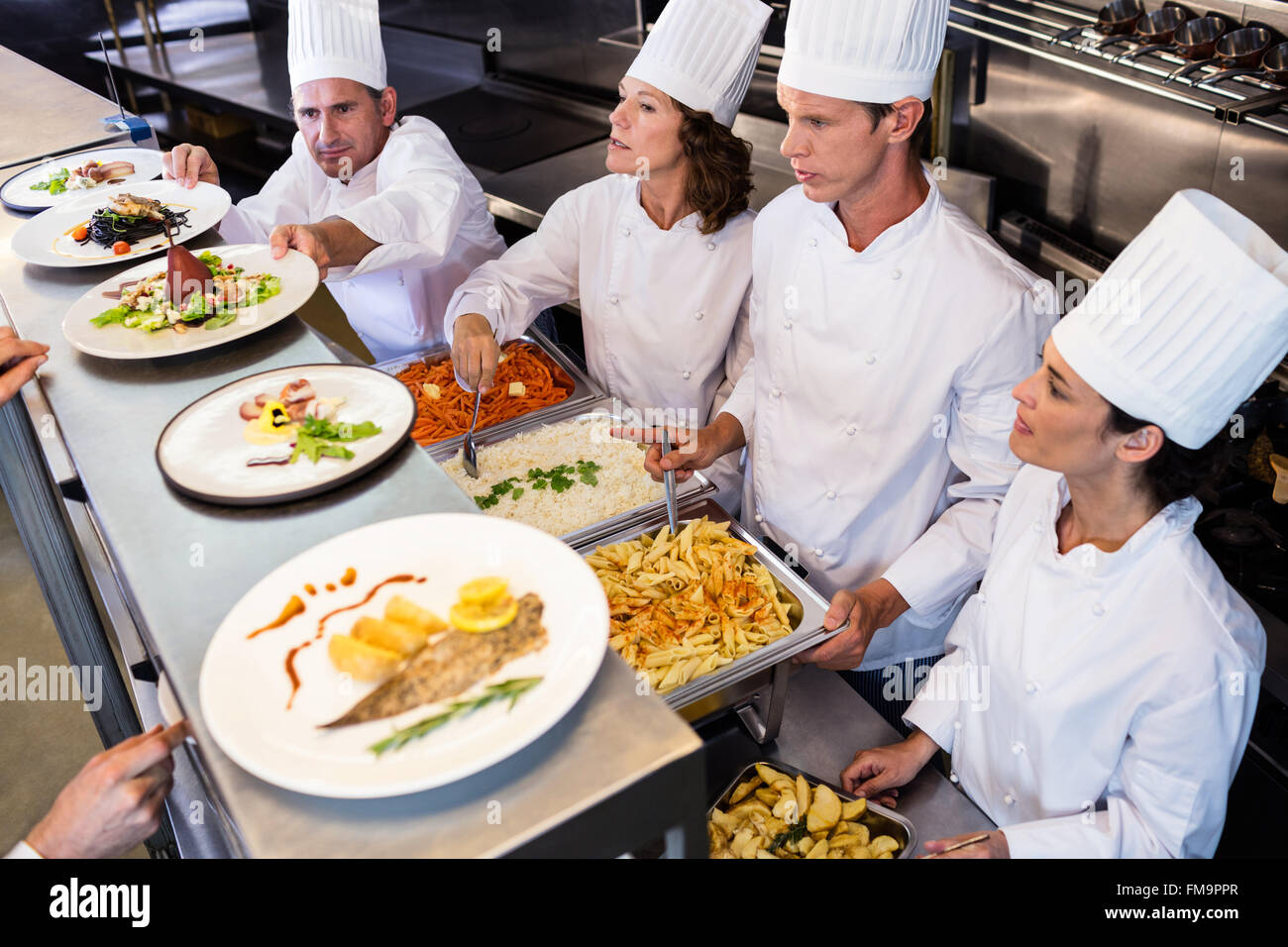 Chefs standing at serving trays of pasta Stock Photo - Alamy