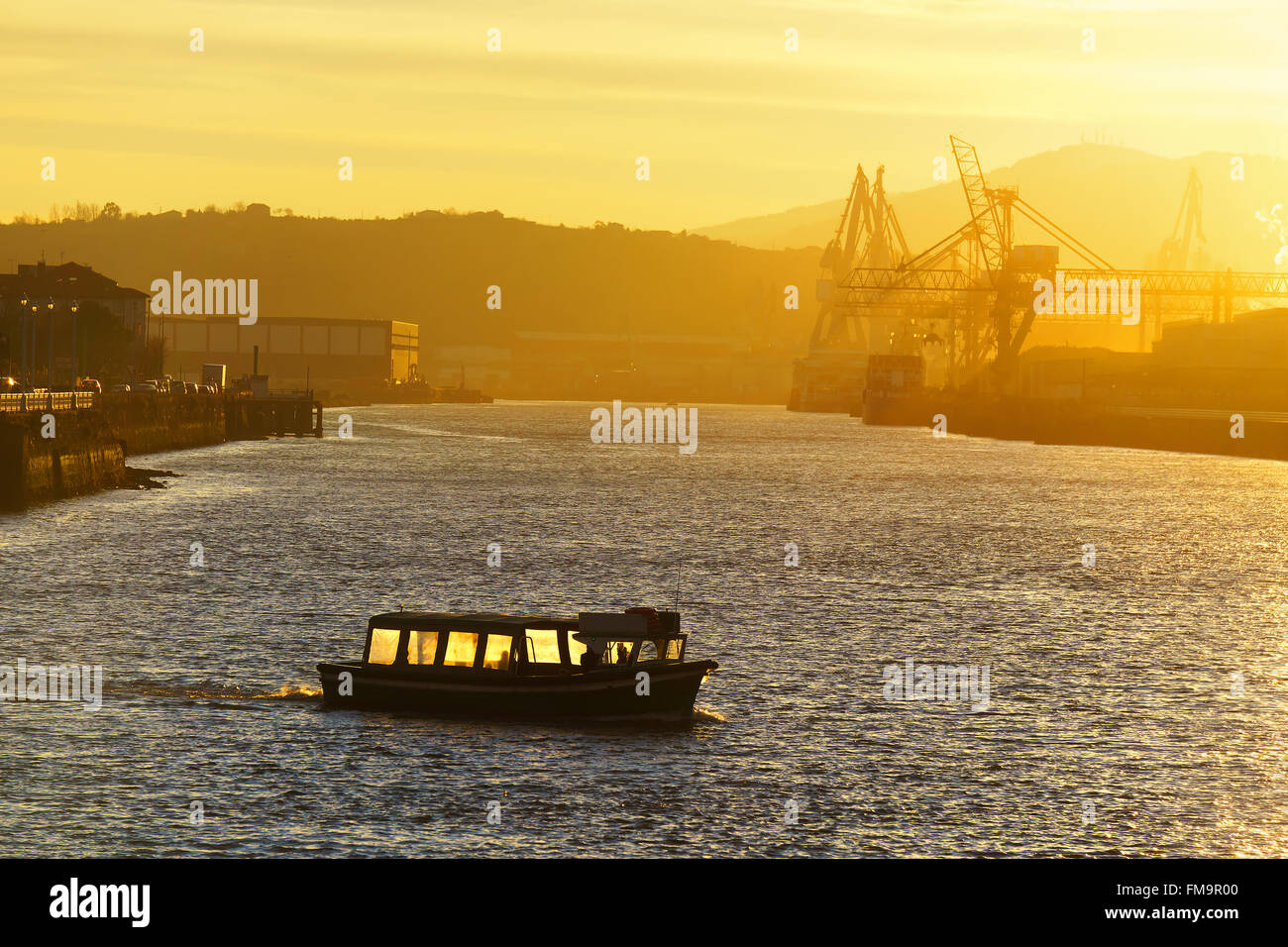 boat transporting people at the sunrise between Getxo and Portugalete Stock Photo