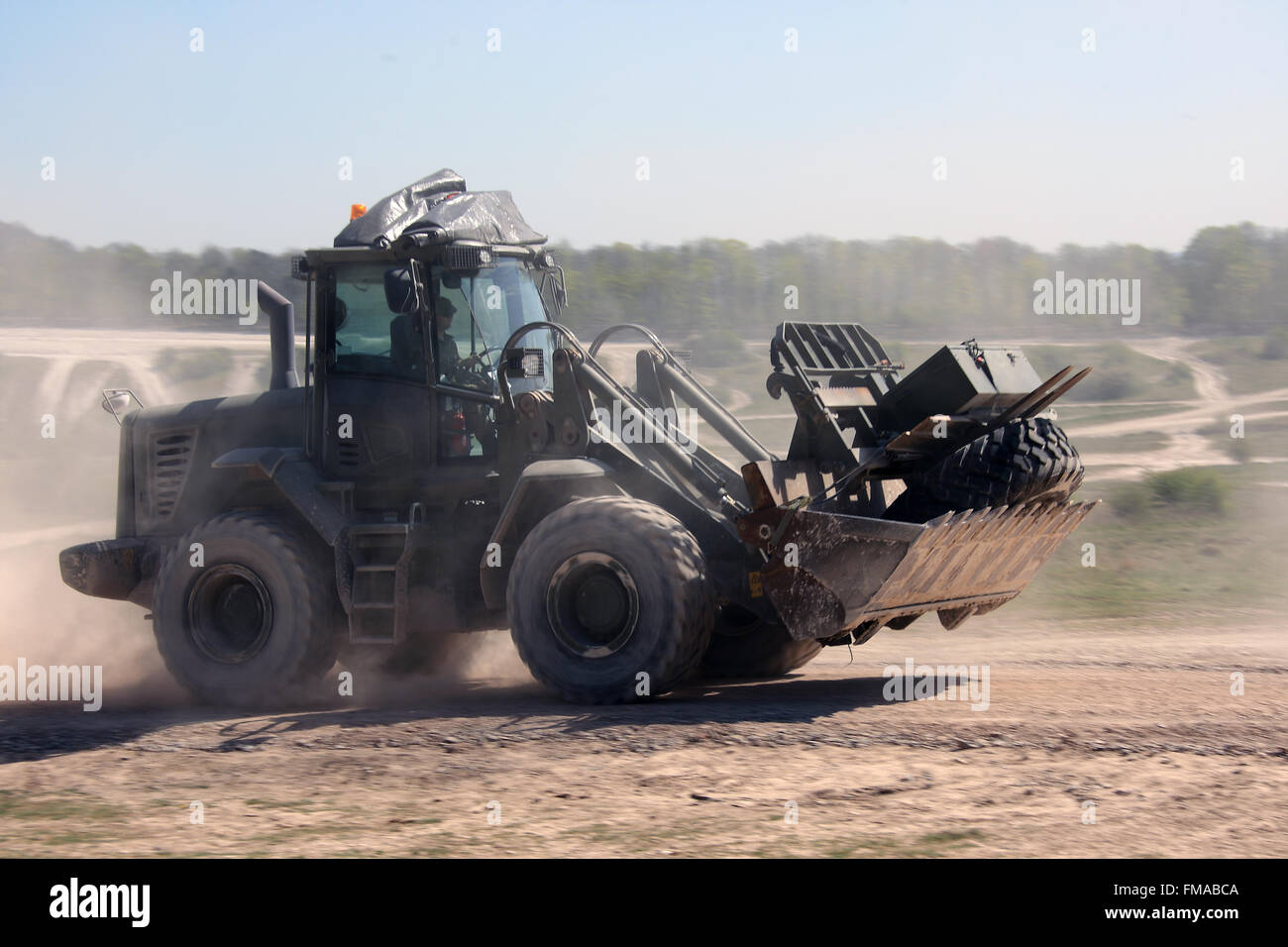 British Army Royal Engineers JCB Bucket loader travels at speed on