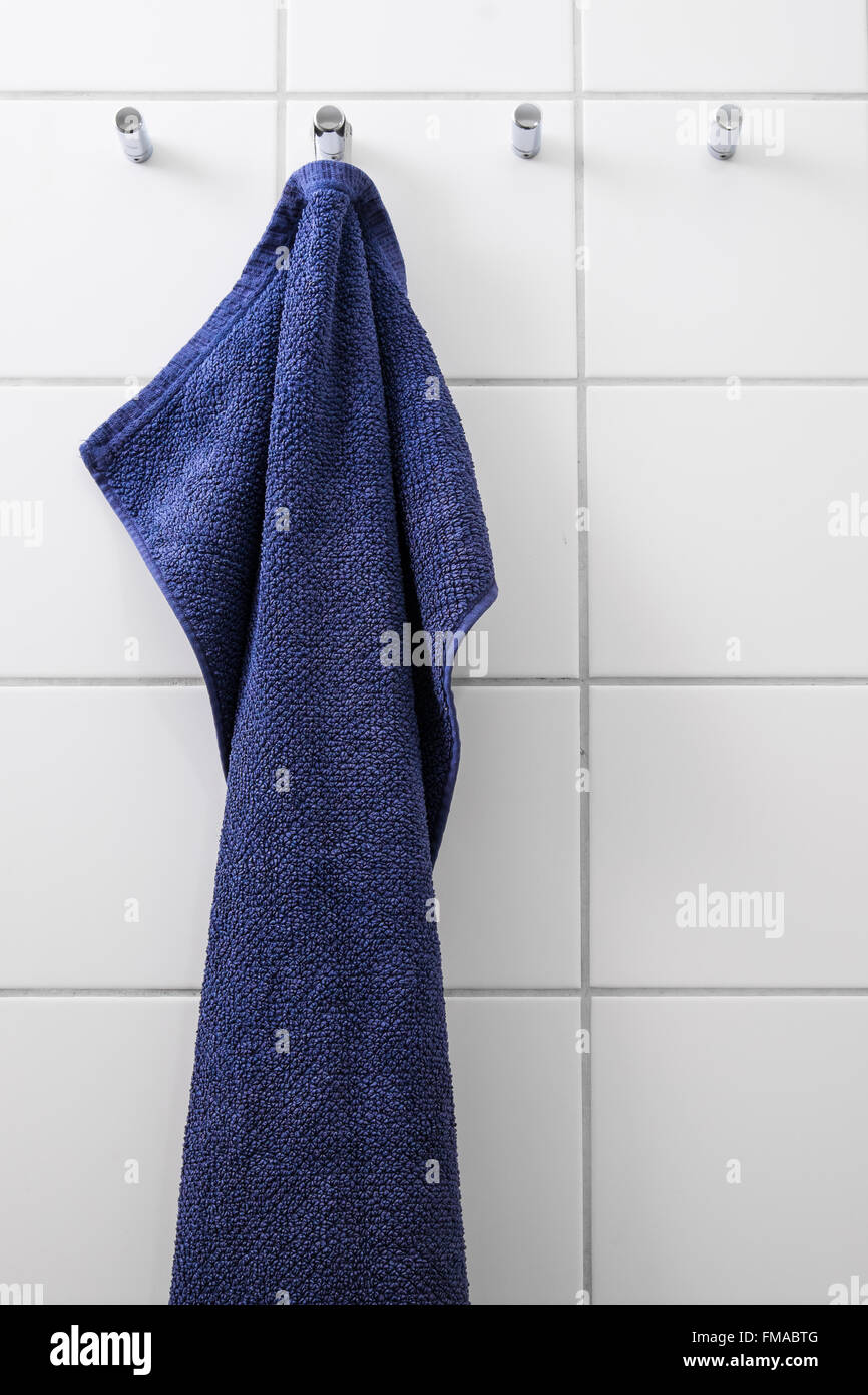 Blue towel hanging on chrome hook Stock Photo