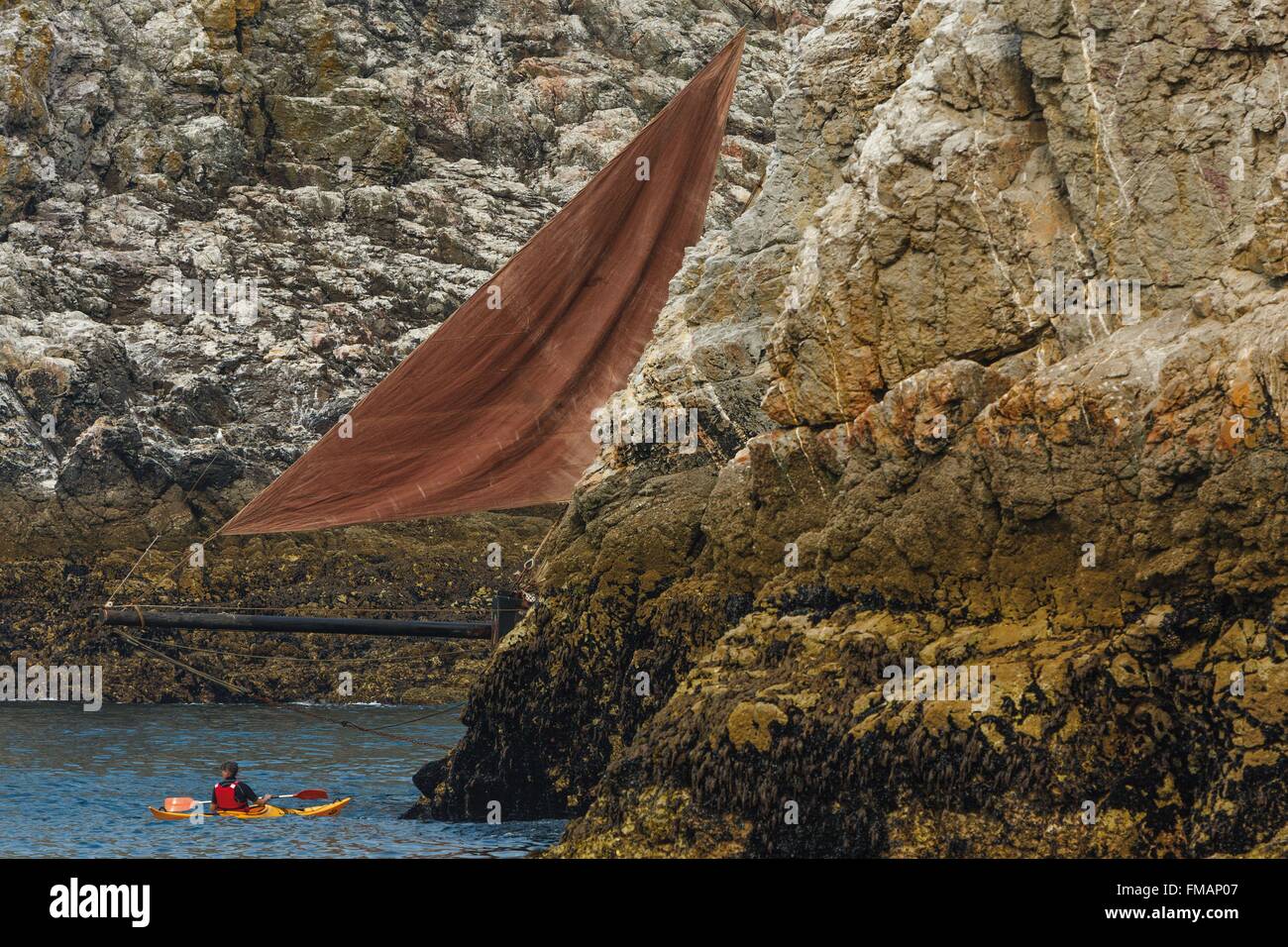 France, Finistere, Douarnenez, Appearance of the front of a sailboat in a pass between two rocks Stock Photo