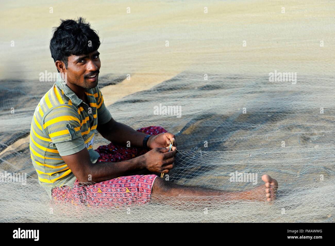 India, Odisha, Chandrabhaga, A fisherman repairs his fishing net Stock