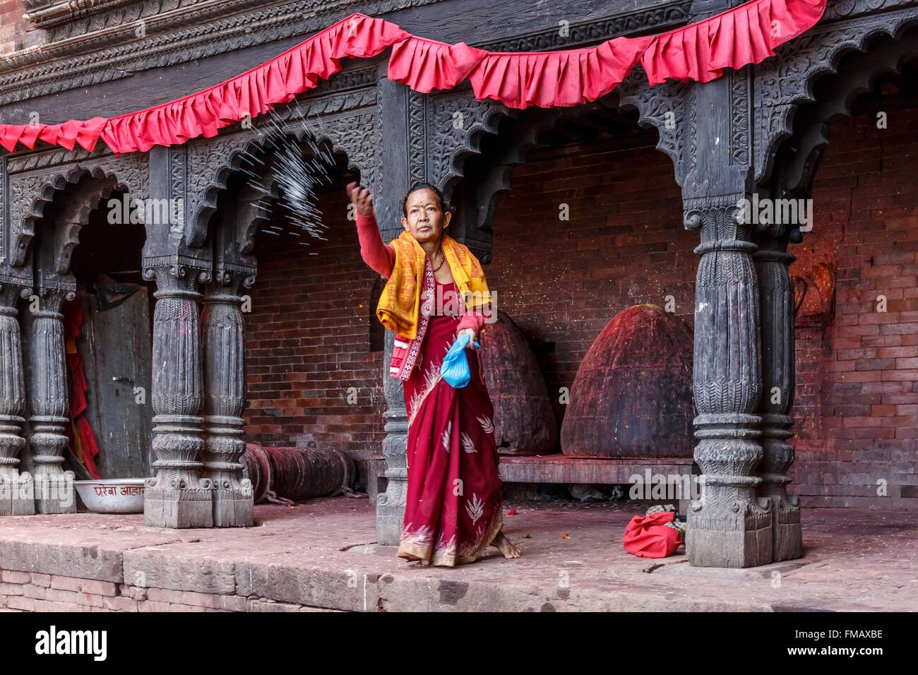 Nepal, Gandaki zone, Gorkha, a woman throwing rice in the Gorkha Durbar Stock Photo