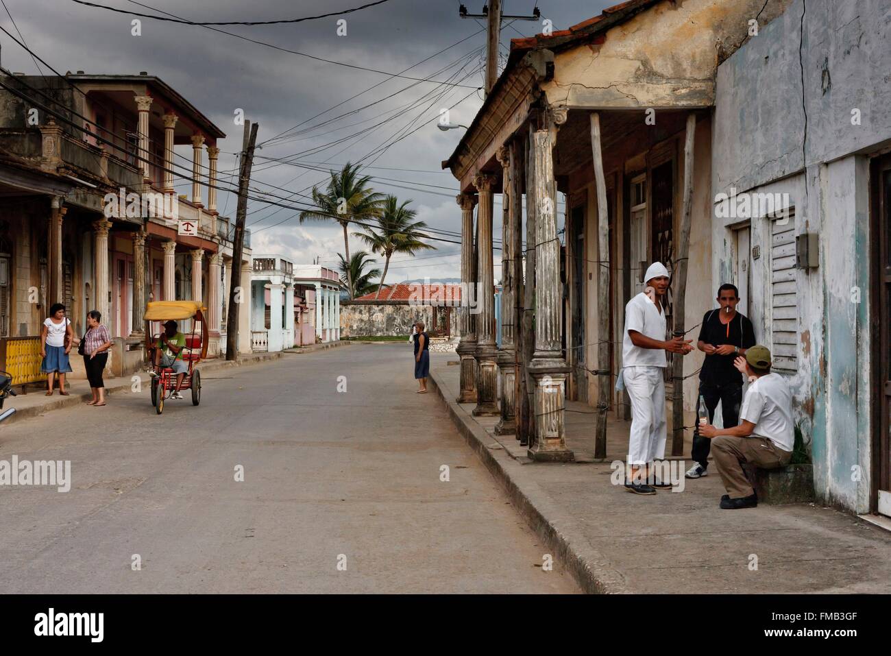 Cuba, Guantanamo, Baracoa, Village street with dilapidated houses with a taxi bike Stock Photo
