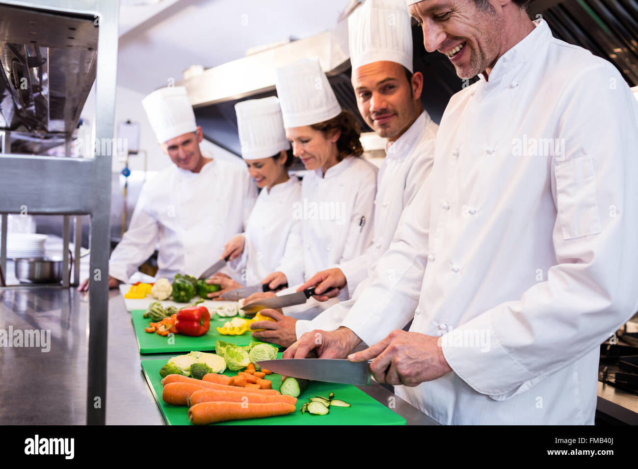Team of chefs chopping vegetables Stock Photo - Alamy