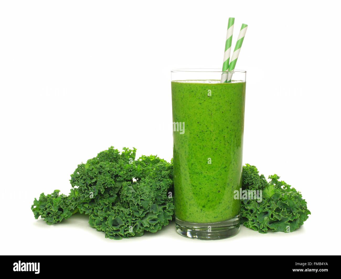 Healthy green smoothie with kale in a glass with straws isolated on a white background Stock Photo