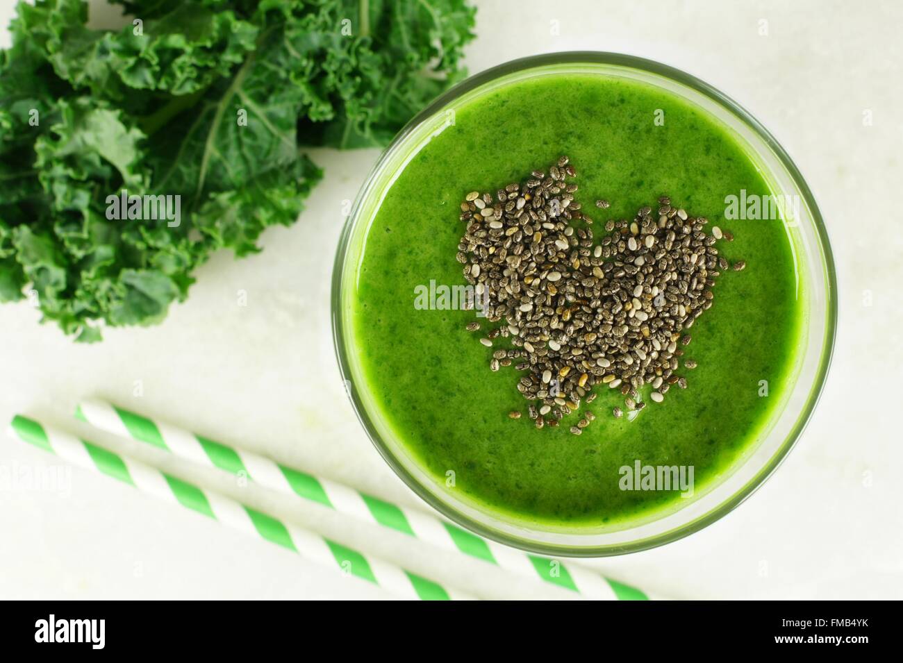 Green kale smoothie in glass with heart of chia seeds. Top view. Stock Photo