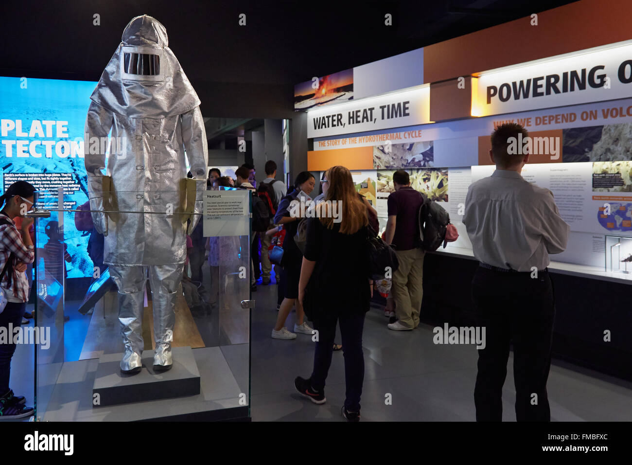 Natural History Museum, Volcanoes and Earthquakes exhibition with visitors and silver heat suit in London Stock Photo