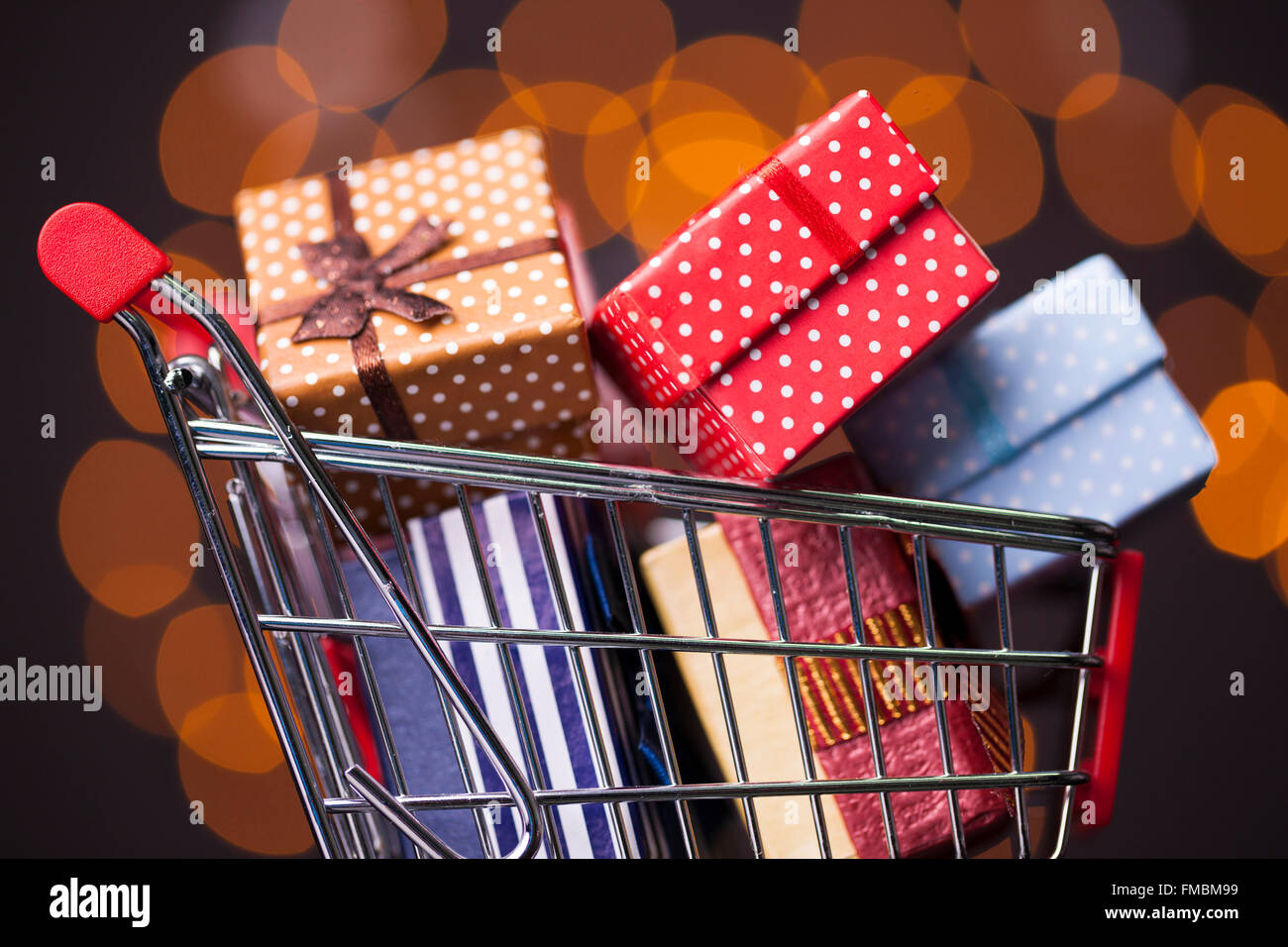 Shooping cart full of gift boxes on dark background Stock Photo