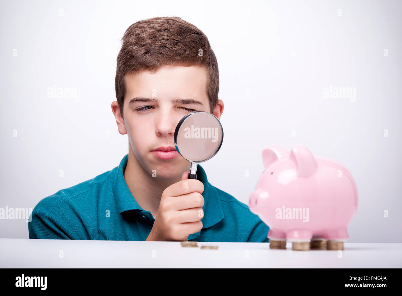 Boy with magnifying glass looking to his savings Stock Photo Alamy