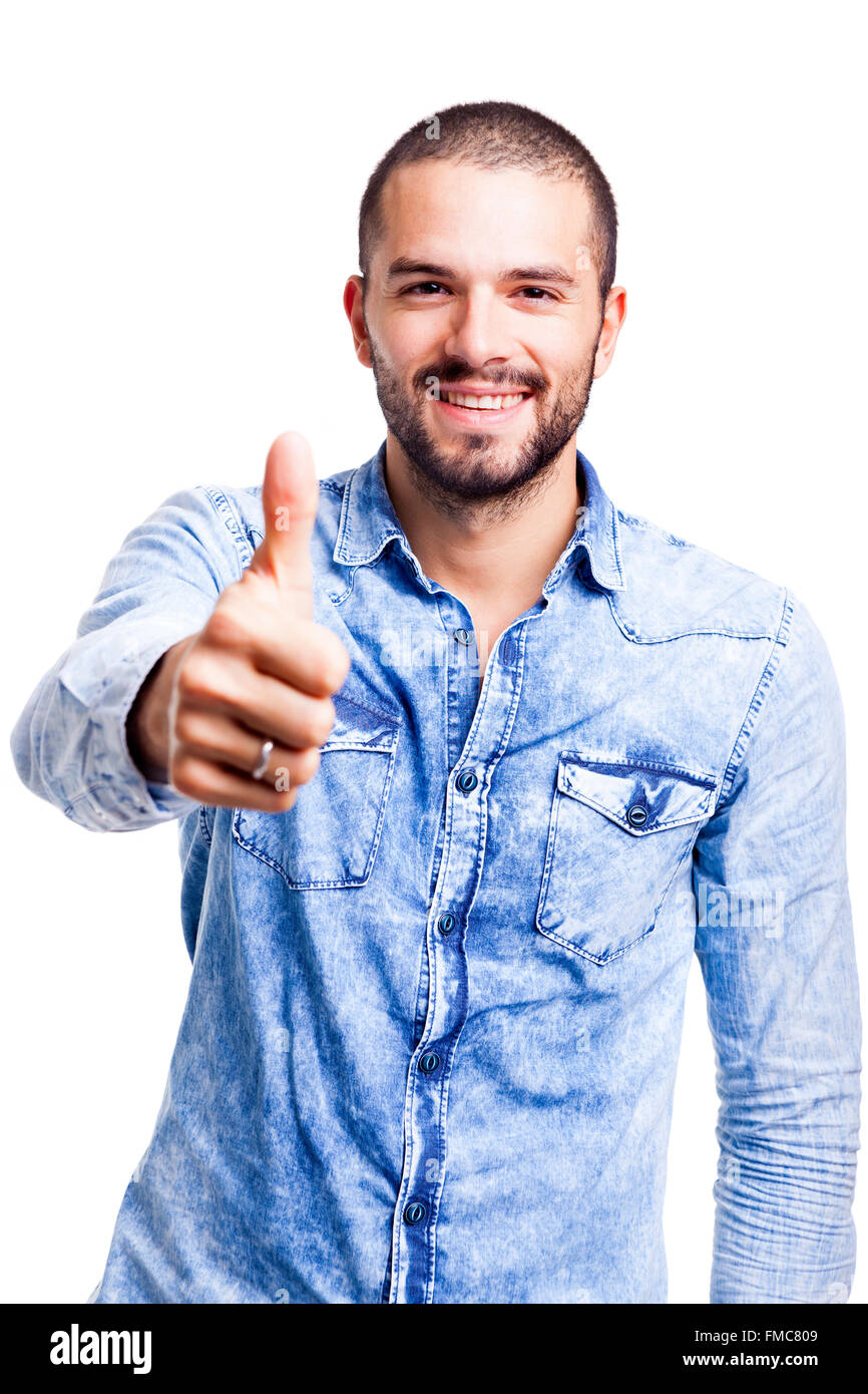 Young casual man thumbs up over white background Stock Photo - Alamy