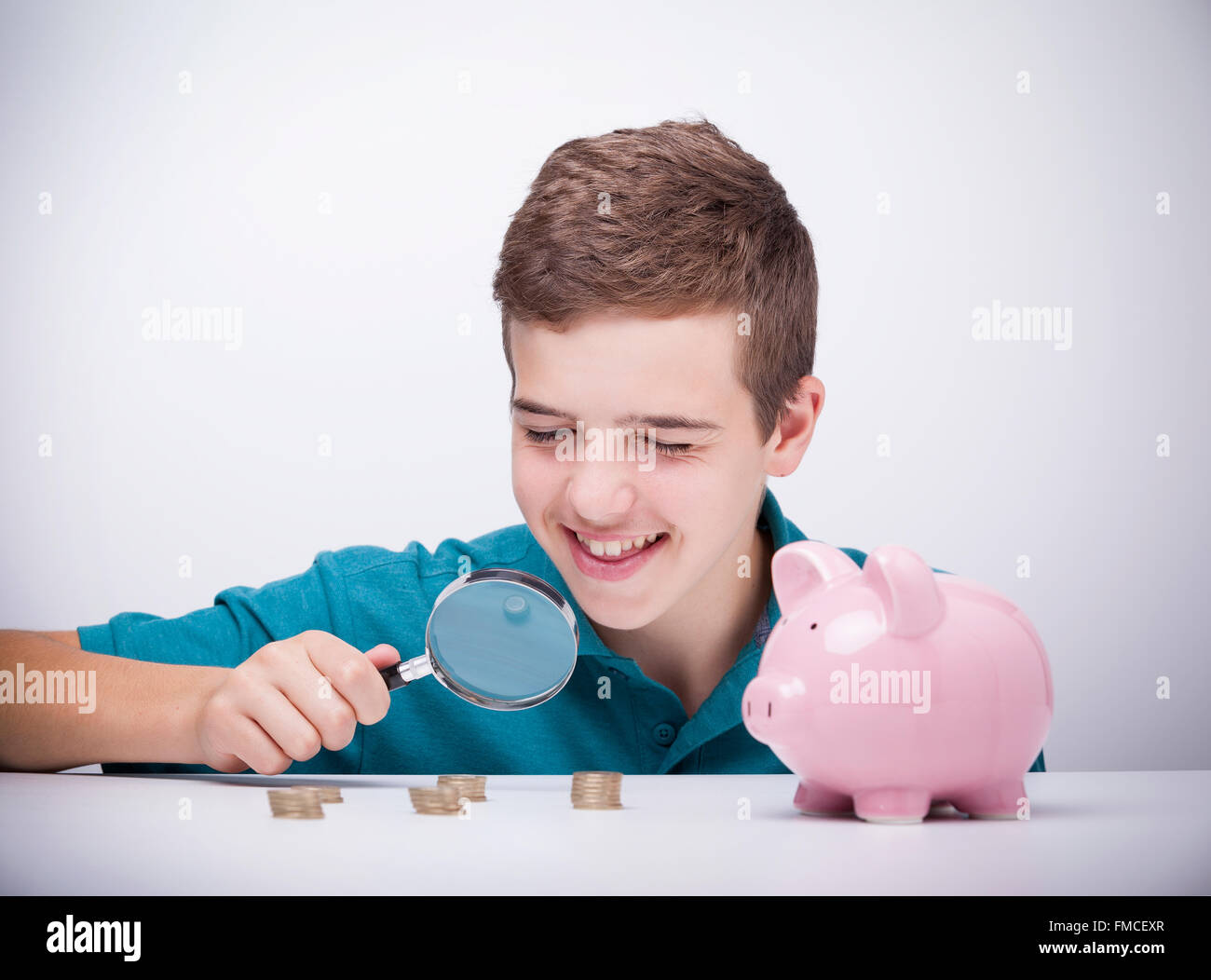 Boy with magnifying glass looking to his savings Stock Photo Alamy