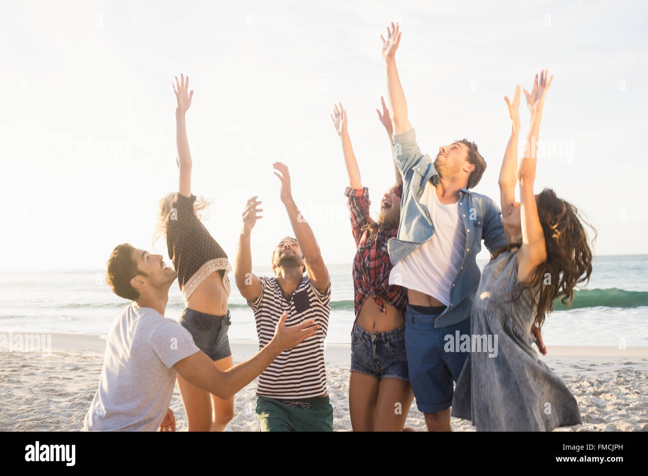 Happy friends playing beach volleyball Stock Photo