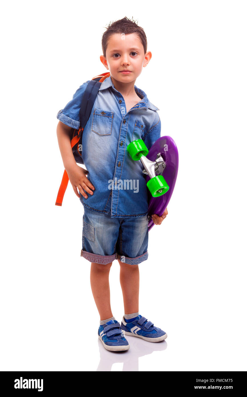 Schoolboy standing with a skateboard and backpack on white background ...